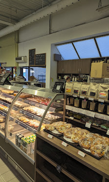 Interior of bakery with glass pastry case and wooden shelves