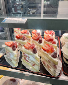 Slices of strawberry shortcake with berries and cream